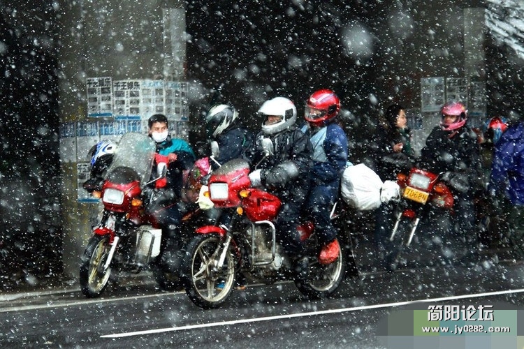月19日，骑着摩托返乡的春运大军冒着大雪返乡。他们身穿厚实的棉衣外加雨衣，头戴防风.jpg