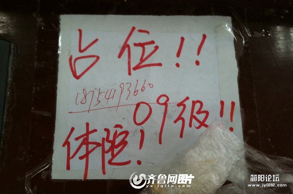 写有“占座”字样的纸张，被占座者用透明胶牢牢地贴在了课桌上。