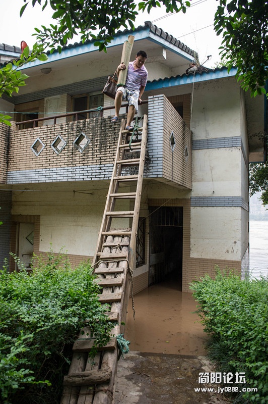 7月23日，由于洪水上涨太快，住在重庆市长滨路的市民只有搭梯子来抢运房间里的物品。1.jpg