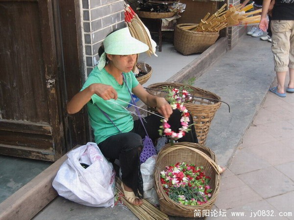 老妈妈在做花环，换取生活费。