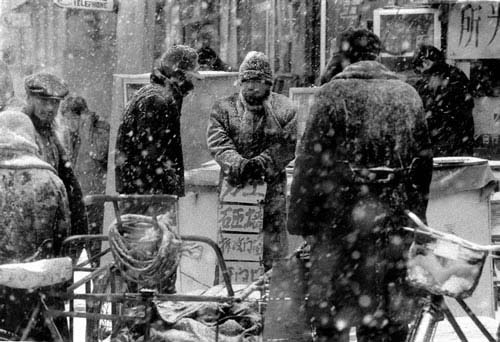 无业人员冒着大雪在零工市场等待雇主.jpg