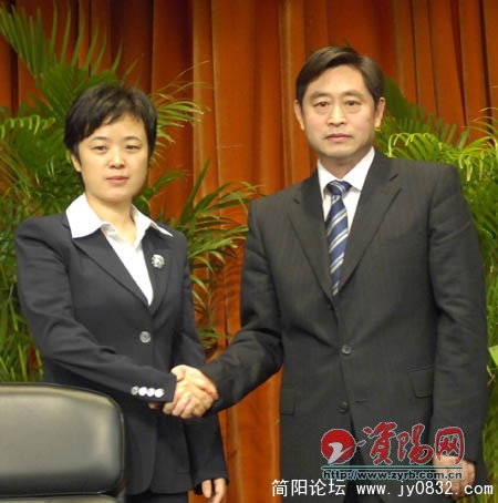 翟占一同志和李佳同志亲切握手。
