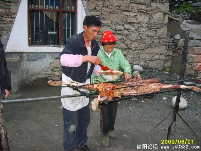 老板扎西次仁给烤羊涂抹调料