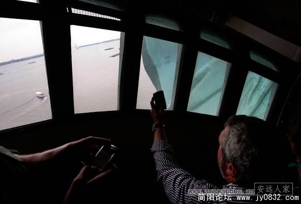 游客用手机在自由女神像王冠上的窗口拍照